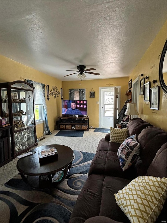 carpeted living room featuring a textured ceiling, ceiling fan, and a wealth of natural light