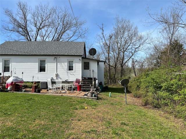 rear view of property featuring a lawn