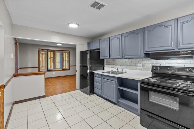 kitchen featuring tasteful backsplash, light tile floors, black appliances, and sink