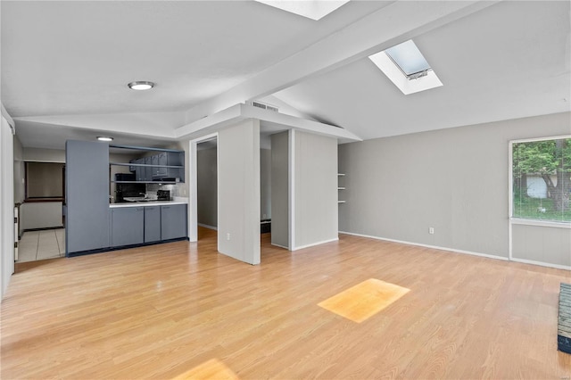 unfurnished living room with lofted ceiling with skylight and light hardwood / wood-style floors