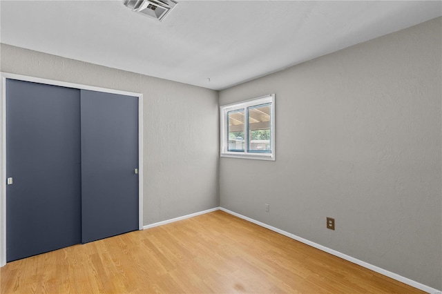 unfurnished bedroom featuring a closet and light hardwood / wood-style flooring