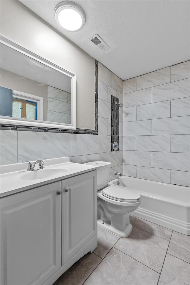 full bathroom with toilet, tiled shower / bath combo, vanity, tile walls, and tile flooring