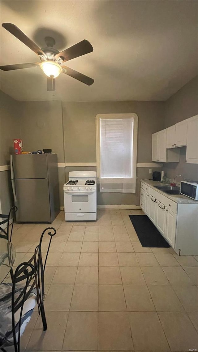 kitchen featuring ceiling fan, white appliances, light tile floors, and white cabinetry