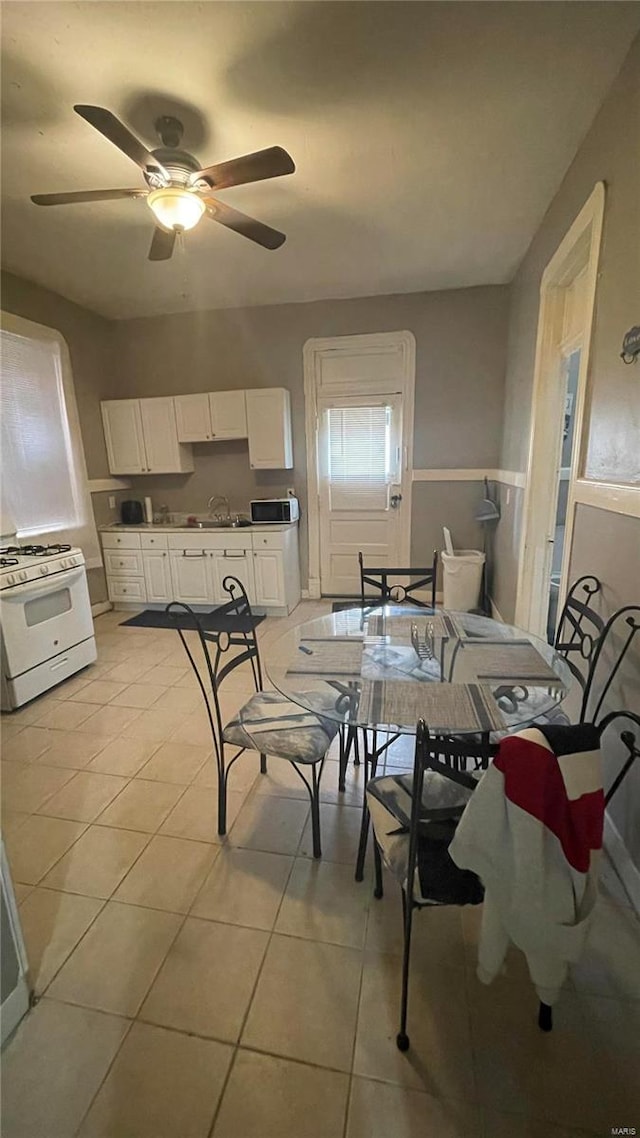 tiled dining room featuring ceiling fan