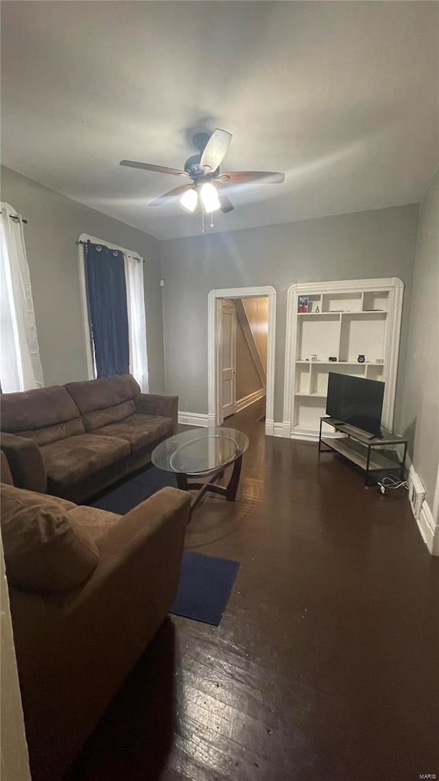 living room with dark hardwood / wood-style flooring and ceiling fan