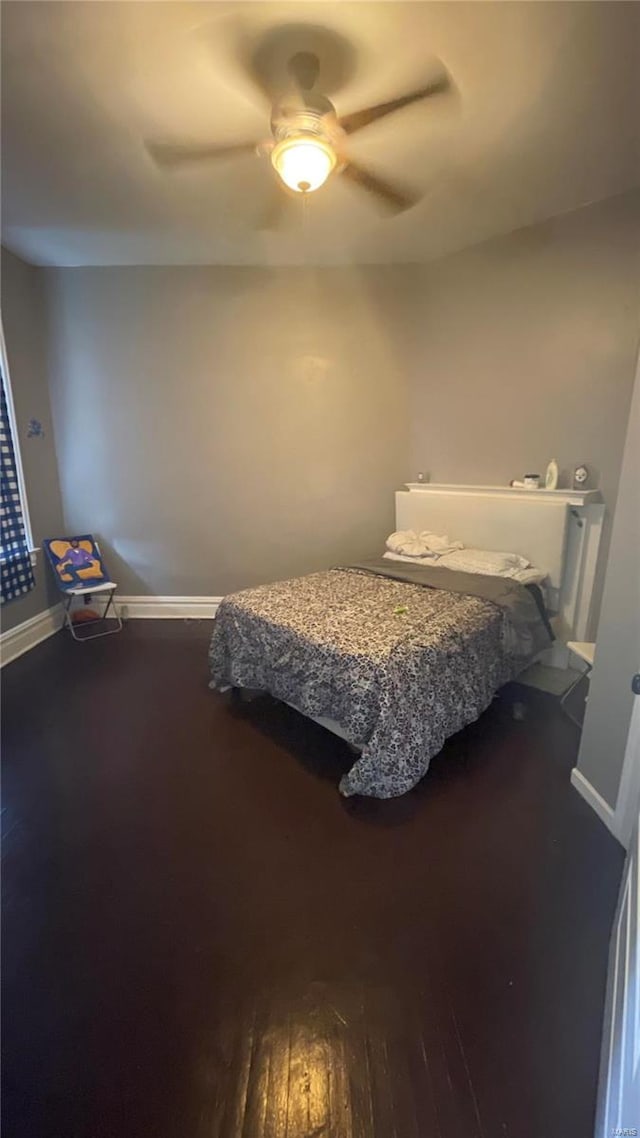 bedroom with dark hardwood / wood-style flooring and ceiling fan