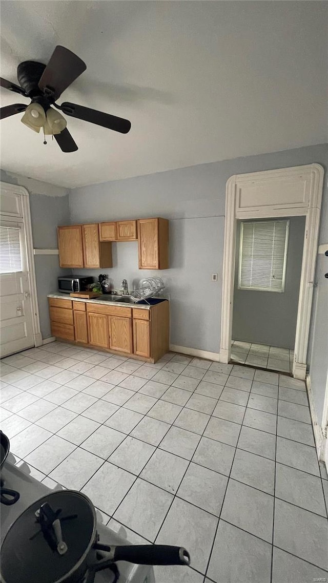 kitchen with ceiling fan, sink, and light tile flooring