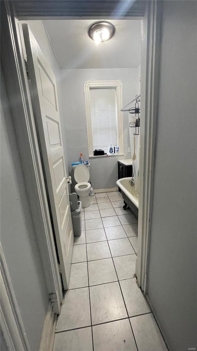 bathroom with toilet and tile floors