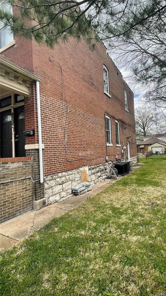 view of side of home featuring central air condition unit and a lawn