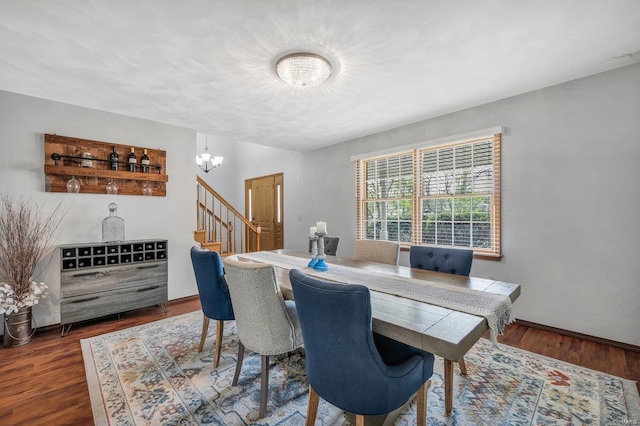 dining space with dark hardwood / wood-style floors and a chandelier