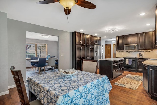 dining space featuring ceiling fan, dark wood-type flooring, and sink