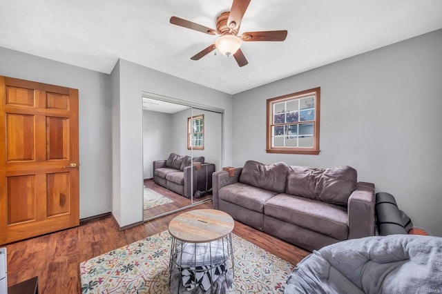 living room with ceiling fan and dark wood-type flooring