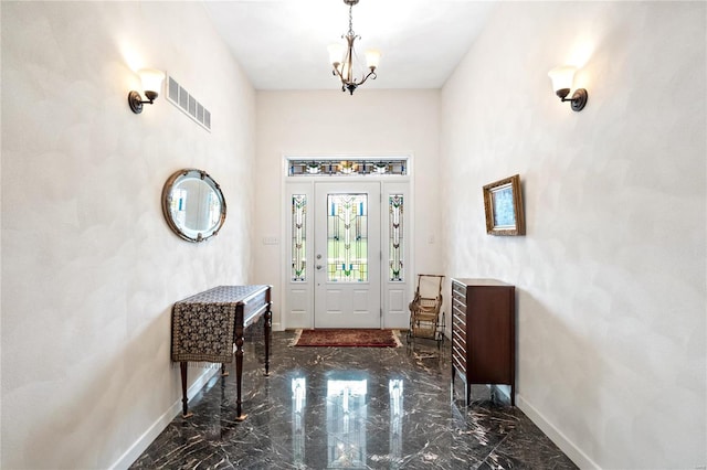 entrance foyer featuring an inviting chandelier and dark tile flooring