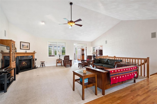 living room with ceiling fan, a premium fireplace, high vaulted ceiling, light hardwood / wood-style flooring, and french doors