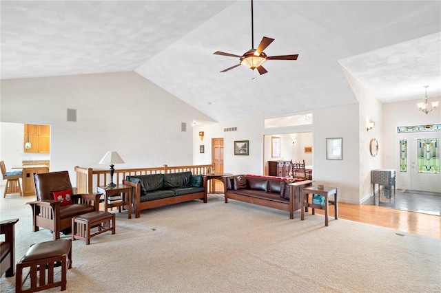 living room with light carpet, high vaulted ceiling, and ceiling fan with notable chandelier