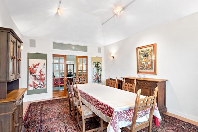 dining room featuring dark hardwood / wood-style flooring, french doors, and track lighting