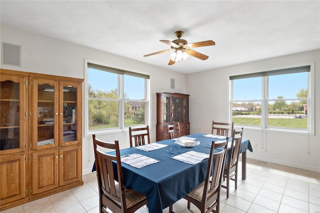 tiled dining room with a wealth of natural light and ceiling fan