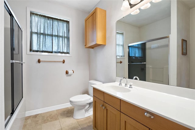 bathroom with tile flooring, large vanity, toilet, and a healthy amount of sunlight