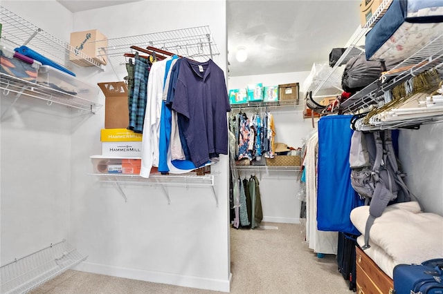 walk in closet featuring light carpet