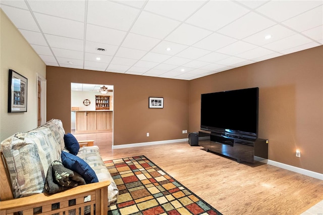 living room with ceiling fan, a paneled ceiling, and light hardwood / wood-style floors