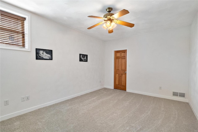 spare room with ceiling fan and light colored carpet