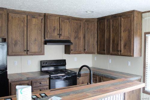 kitchen featuring sink, black appliances, and a textured ceiling