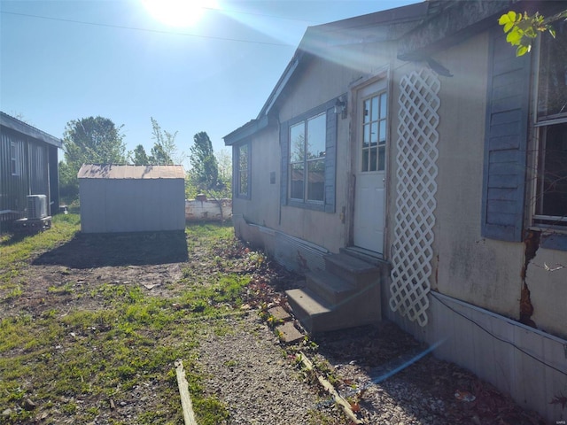 view of home's exterior featuring a storage unit and central AC unit