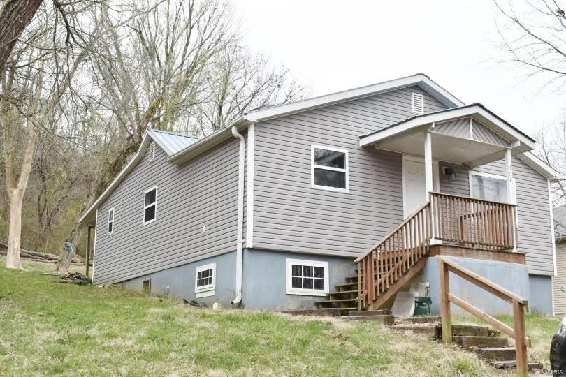 rear view of house with a yard