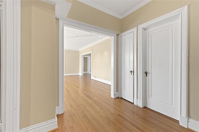 corridor featuring ornamental molding and light hardwood / wood-style flooring