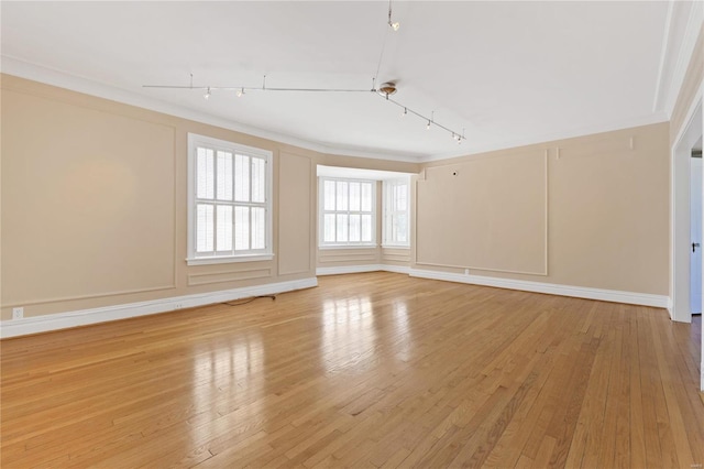 unfurnished room with light hardwood / wood-style floors, ornamental molding, and track lighting