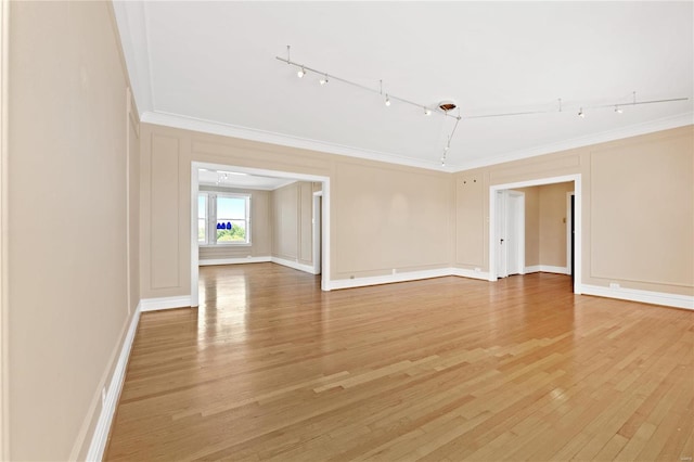 unfurnished room with crown molding, track lighting, and hardwood / wood-style floors