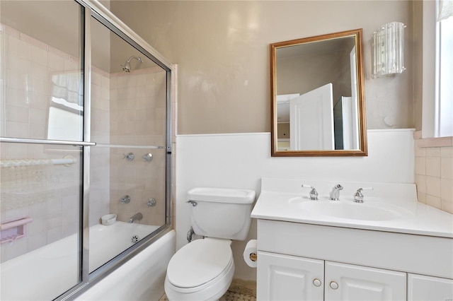 full bathroom featuring vanity, enclosed tub / shower combo, and toilet