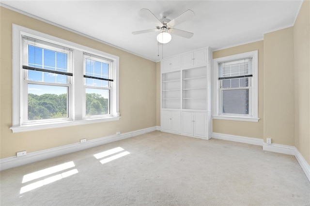 carpeted empty room featuring crown molding and ceiling fan