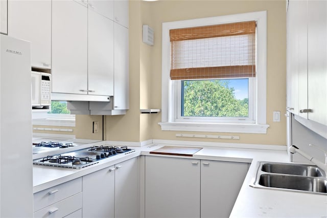 kitchen featuring white cabinets and white appliances