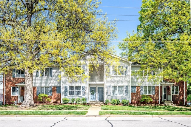 townhome / multi-family property featuring a front lawn