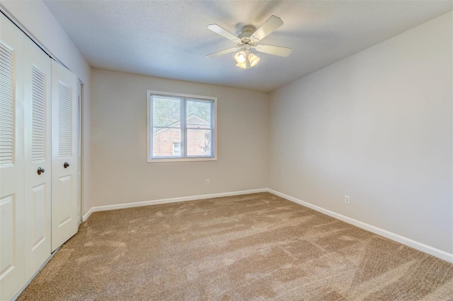 unfurnished bedroom featuring light colored carpet, a closet, and ceiling fan