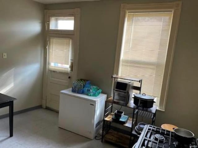 interior space with refrigerator and light tile floors