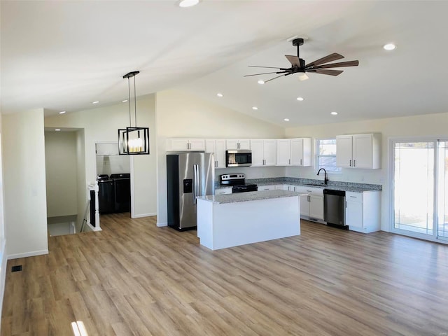 kitchen with appliances with stainless steel finishes, a kitchen island, light hardwood / wood-style floors, white cabinetry, and pendant lighting