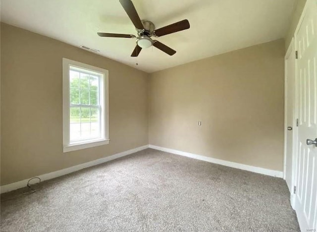 spare room featuring light colored carpet and ceiling fan