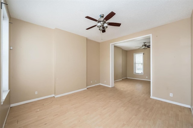 unfurnished room featuring a textured ceiling, ceiling fan, and light wood-type flooring