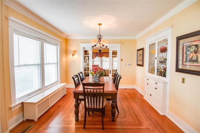 dining space featuring light parquet floors, crown molding, radiator, and a notable chandelier