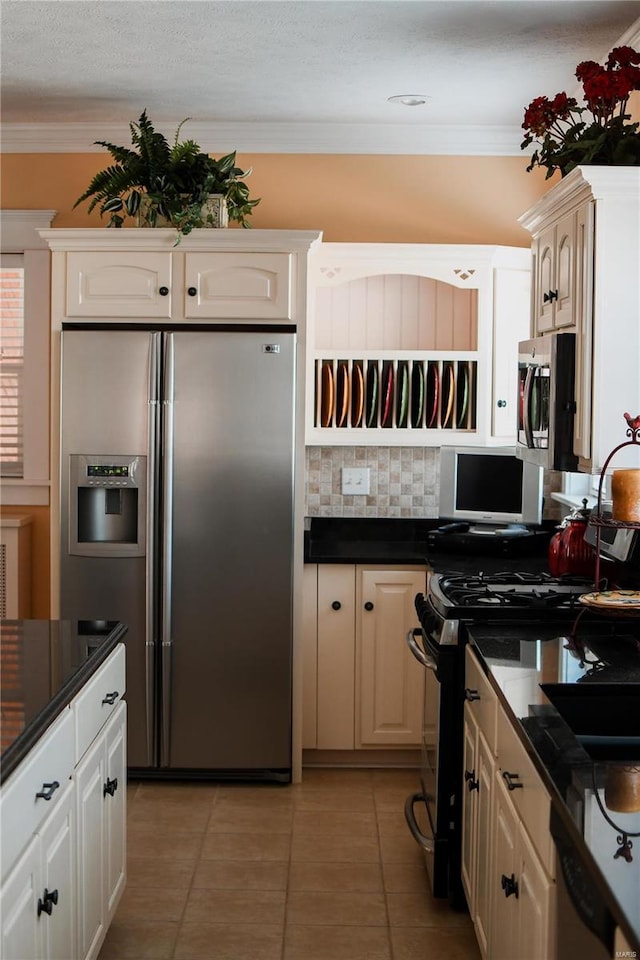 kitchen with ornamental molding, appliances with stainless steel finishes, light tile patterned floors, and backsplash