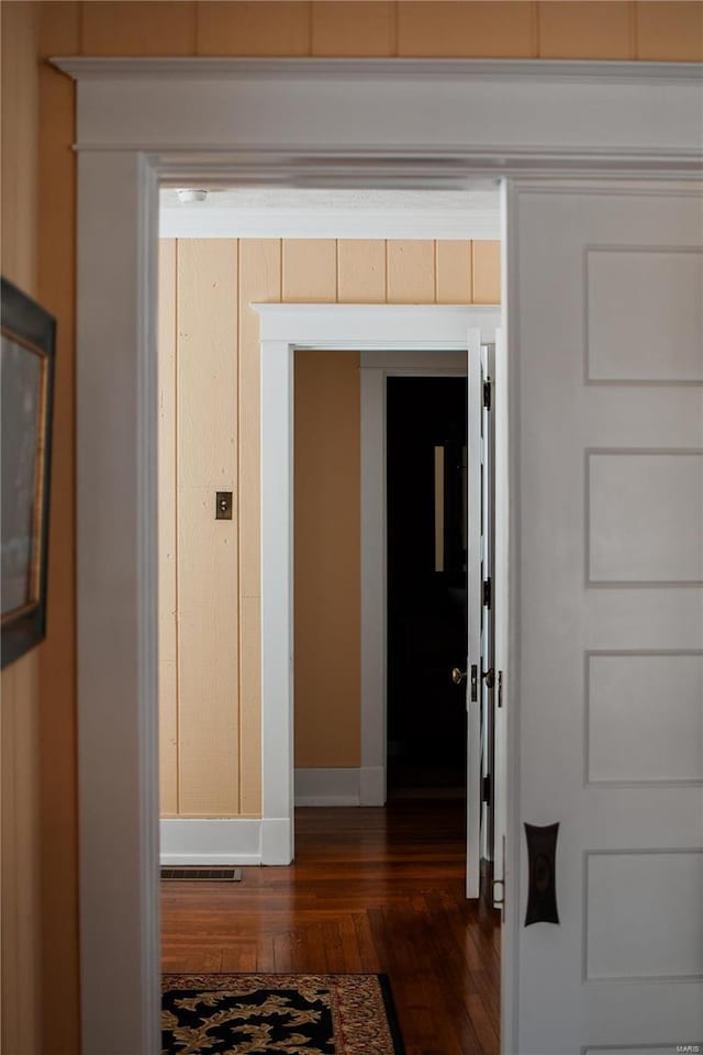 corridor with dark hardwood / wood-style flooring