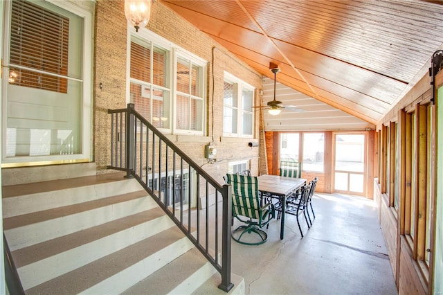 unfurnished sunroom with vaulted ceiling, wooden ceiling, and ceiling fan