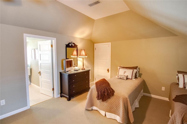 carpeted bedroom with ensuite bathroom and lofted ceiling