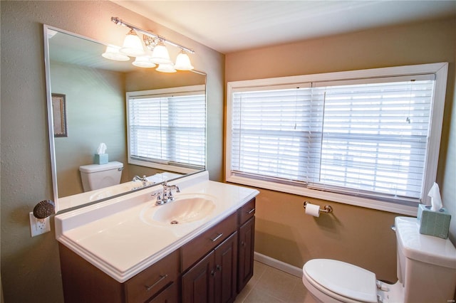 bathroom with vanity, a wealth of natural light, tile patterned floors, and toilet