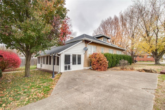 view of home's exterior featuring a yard and a sunroom