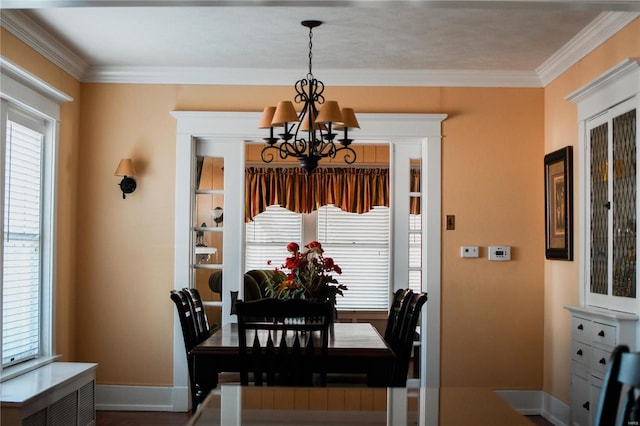 dining area with a notable chandelier, crown molding, and a wealth of natural light