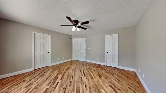 empty room featuring light hardwood / wood-style floors, ceiling fan, and a textured ceiling