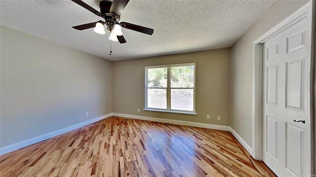 unfurnished room with a textured ceiling, ceiling fan, and light wood-type flooring